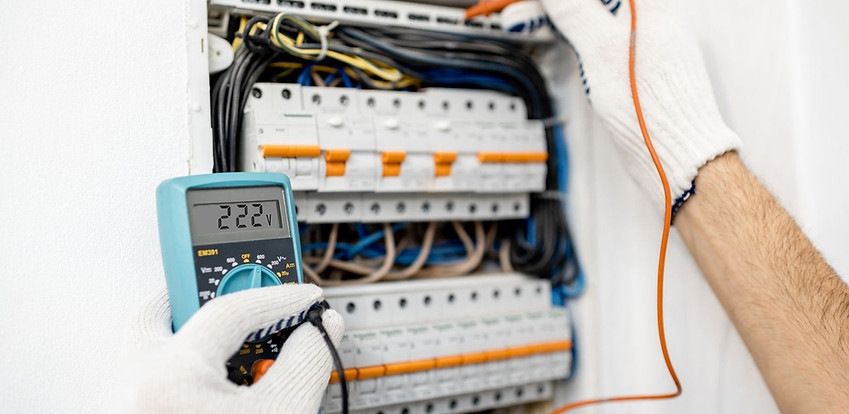 Electrician testing electrical panel with multimeter Electrician testing electrical panel with multimeter